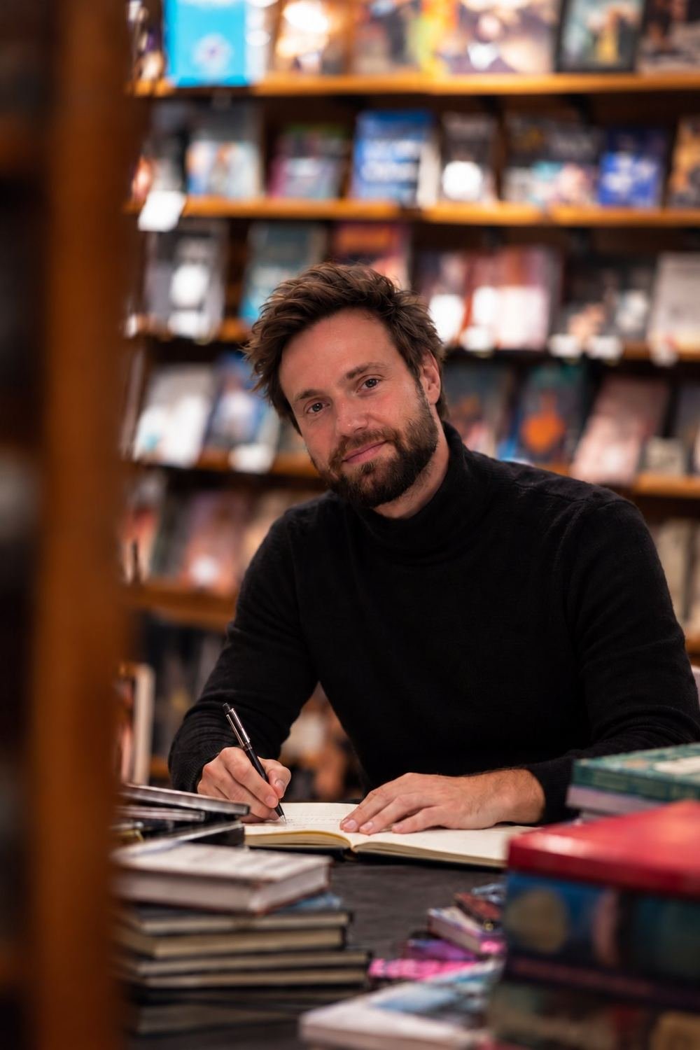 Roman writing at a table in a bookshop